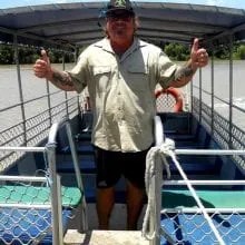 a man standing on a dock next to a fence